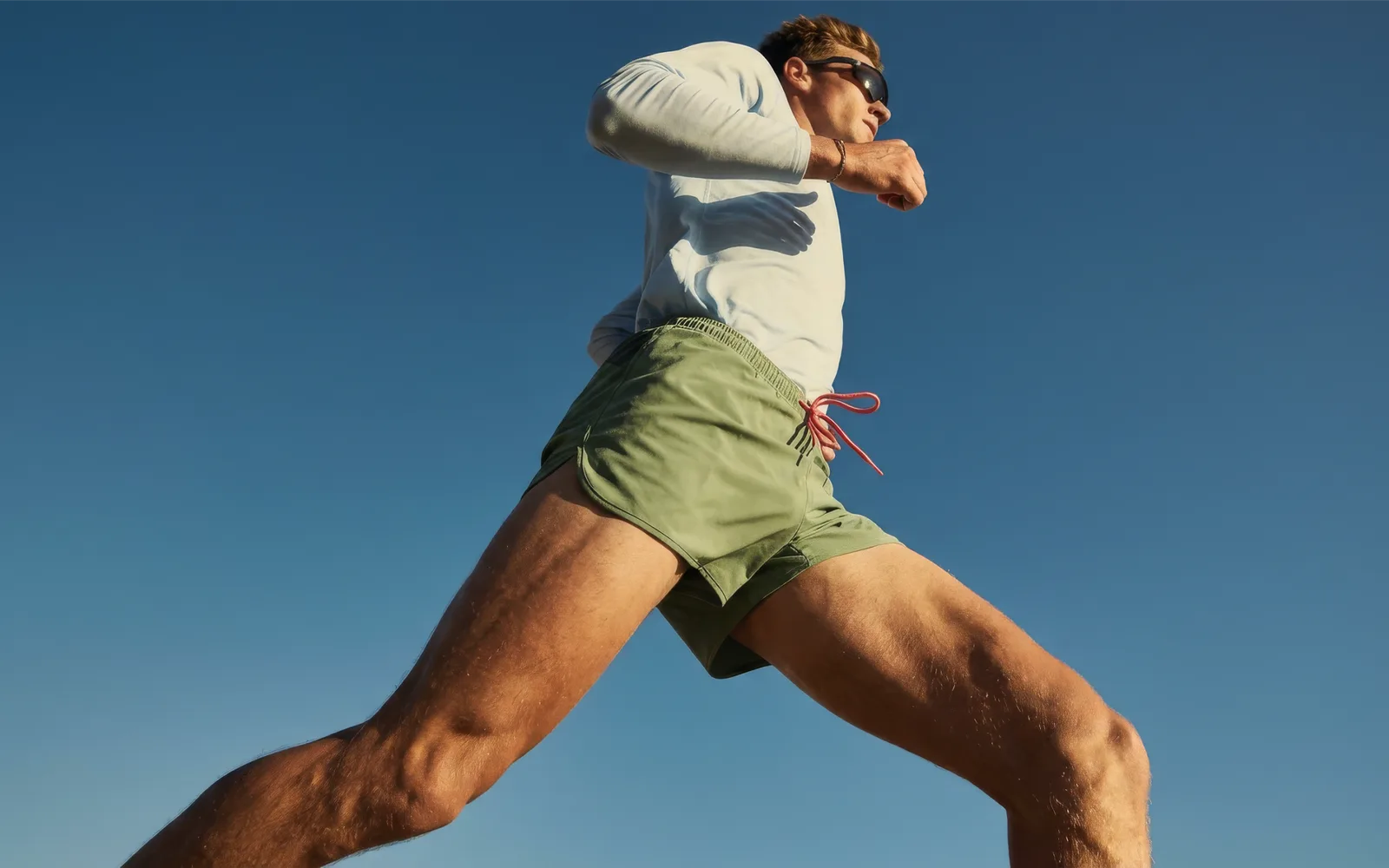 Performance athlete running beneath a clear blue sky for Hema Health